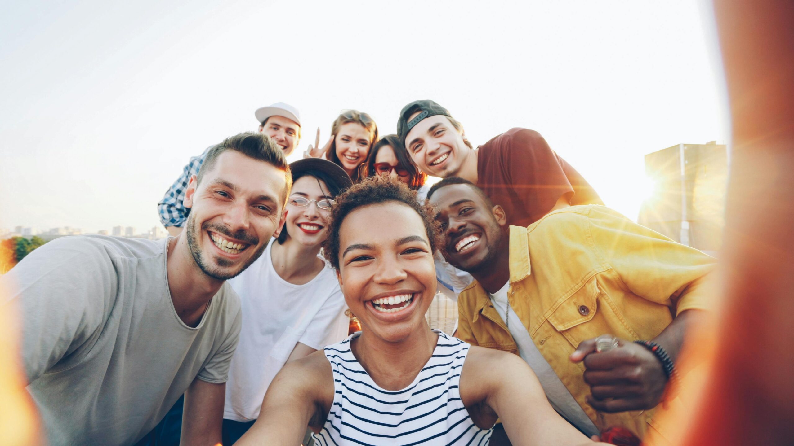services-04 A diverse group of friends taking a joyful selfie outdoors during sunset.