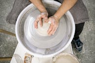 Hands shaping clay on a pottery wheel, emphasizing craftsmanship and artistry.